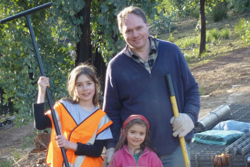 Two young girls and a man on a building site