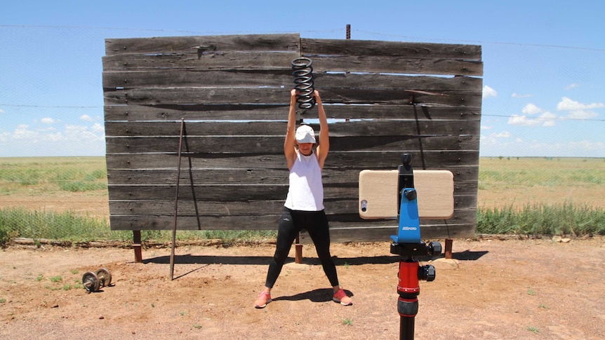 Joy McClymont recording a fitness video in the tennis court on her family's property.