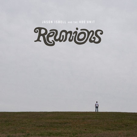 Jason Isbell stands far away against the backdrop of a cloudy sky on the Reunions album cover