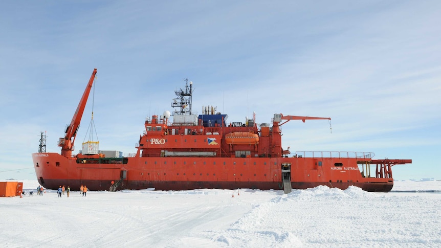 The Aurora Australis icebreaker ship in Antartica surrounded by ice and people.