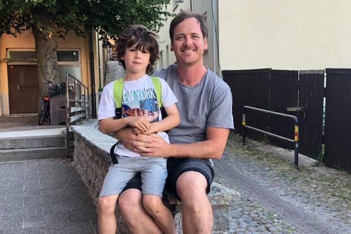Clint Grundy and son sitting on his lap in Sweden.