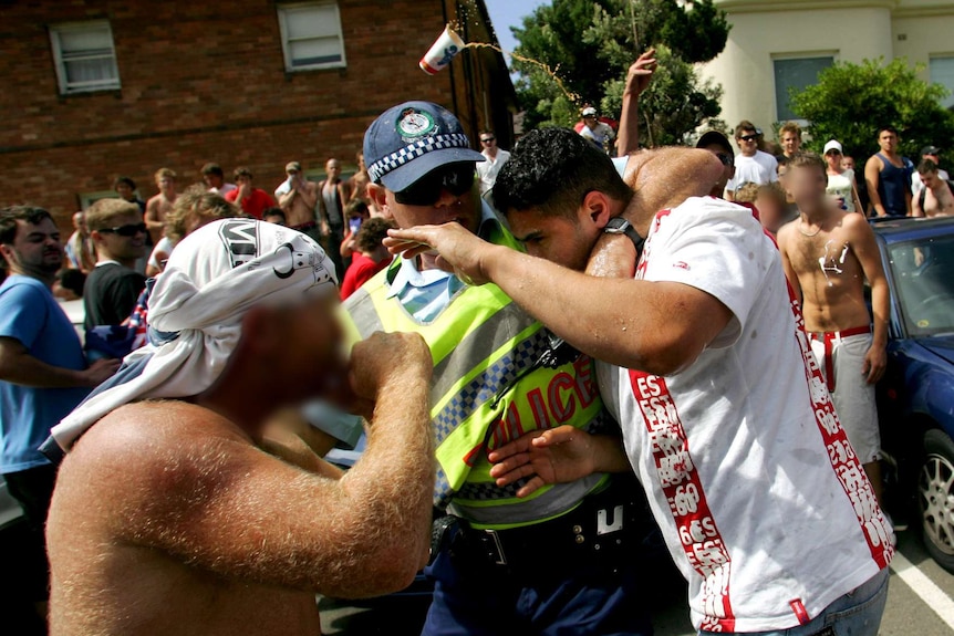 Police help a man set upon by rioters in Cronulla