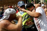 Police help a man set upon by rioters in Cronulla