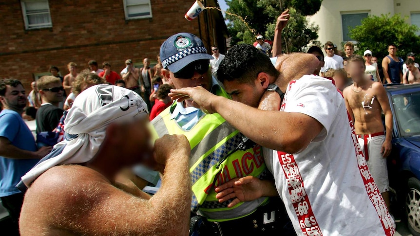 Police help a man set upon by rioters in Cronulla