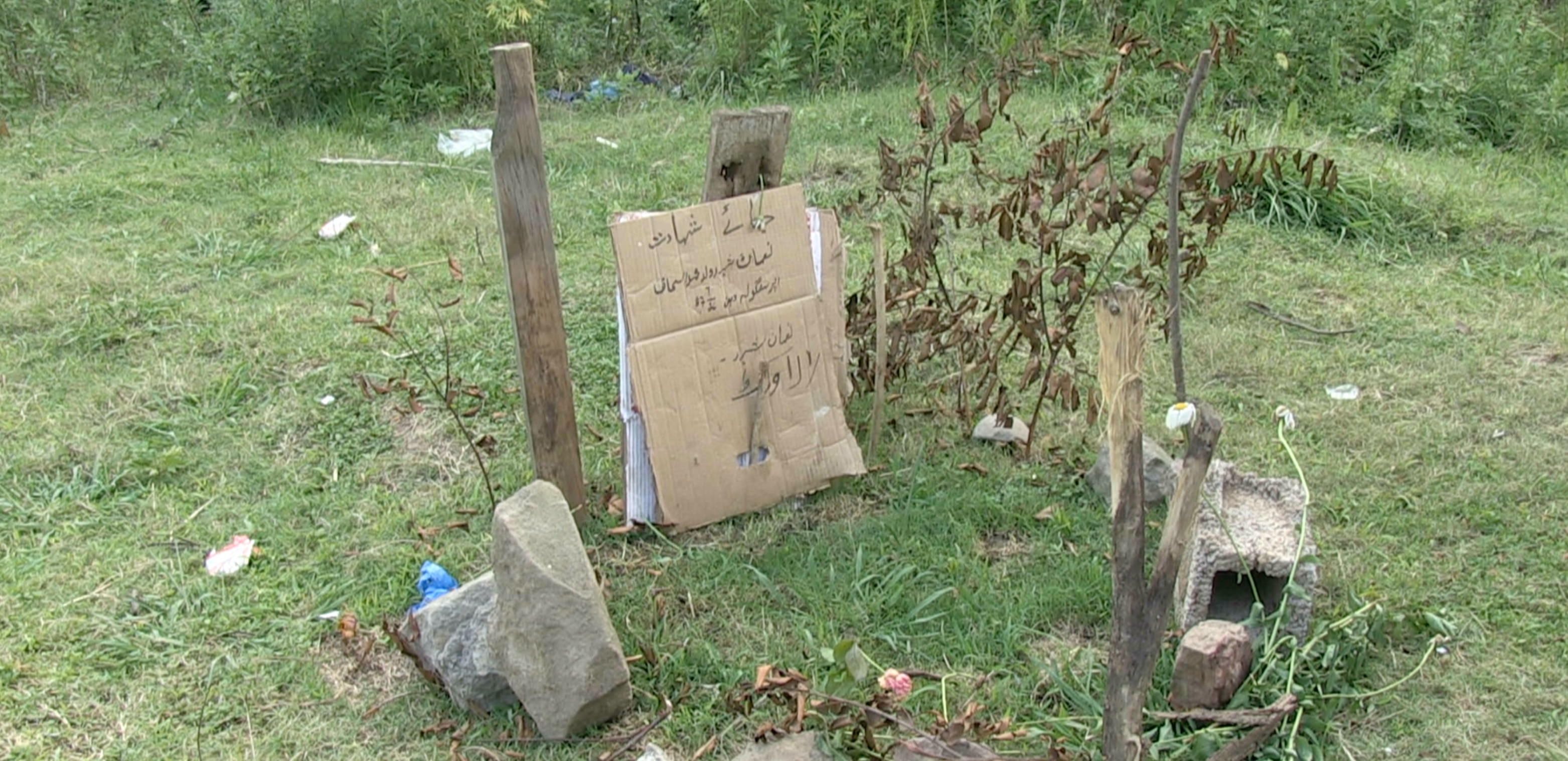 A crude memorial to a missing person in a field