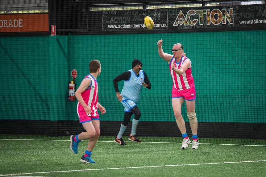 A group of three players with one handballing.