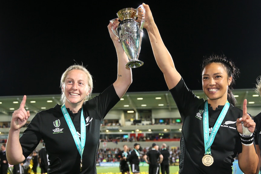 Kelly Brazier and Carla Hohepa lift a silver trophy and point their fingers to the sky