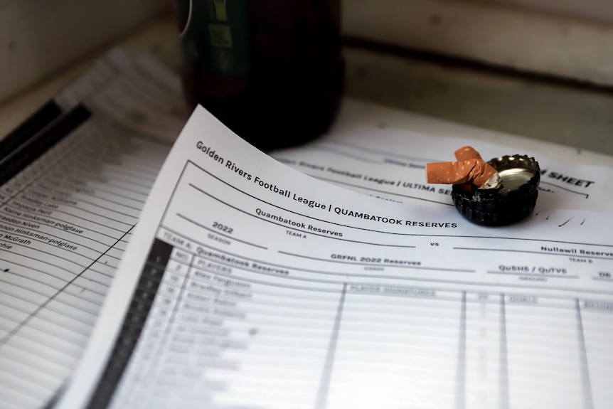 A scorekeepers sheet with two cigarette buts on a table