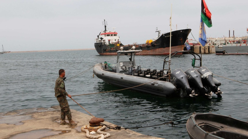 A member of the Libyan coast guard conducts a daily routine check.