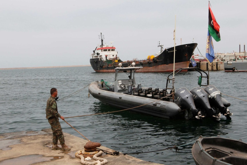 A member of the Libyan coast guard conducts a daily routine check.