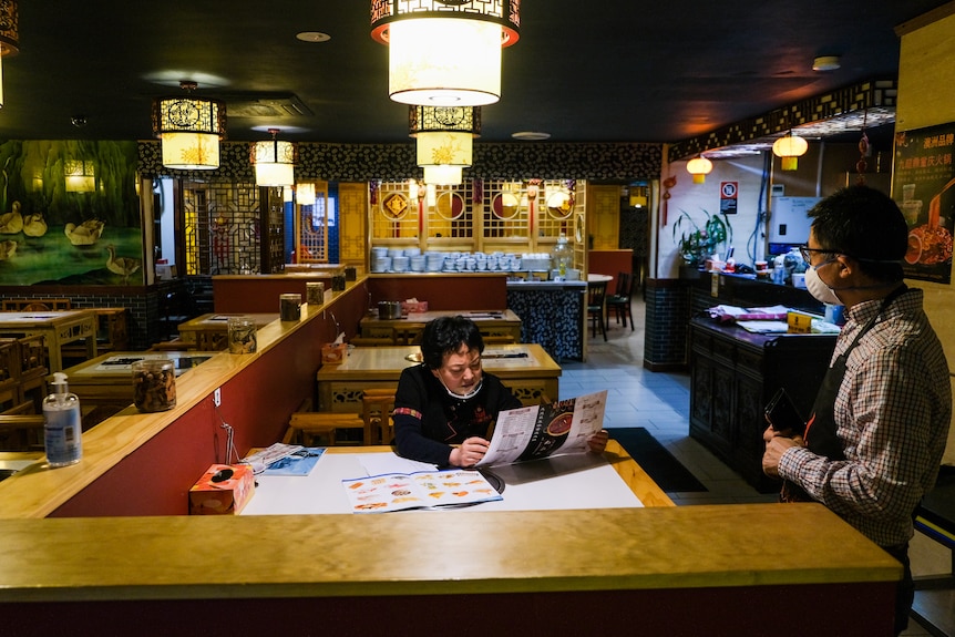 a woman with a menu ordering in a restaurant