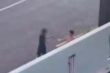 a blurred image of a boy holding a knife to a woman on the street