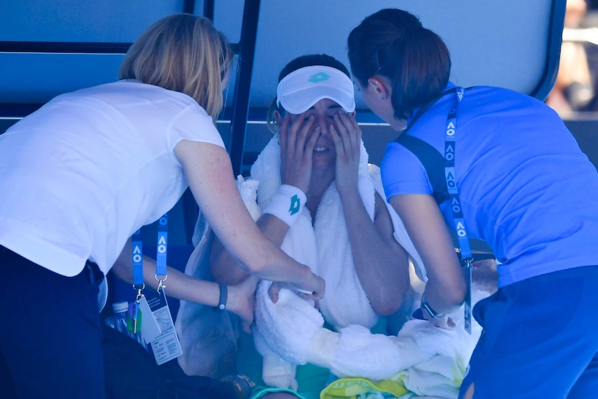 France's Alize Cornet is attended to by trainer after suffering heat stress at the Australian Open.