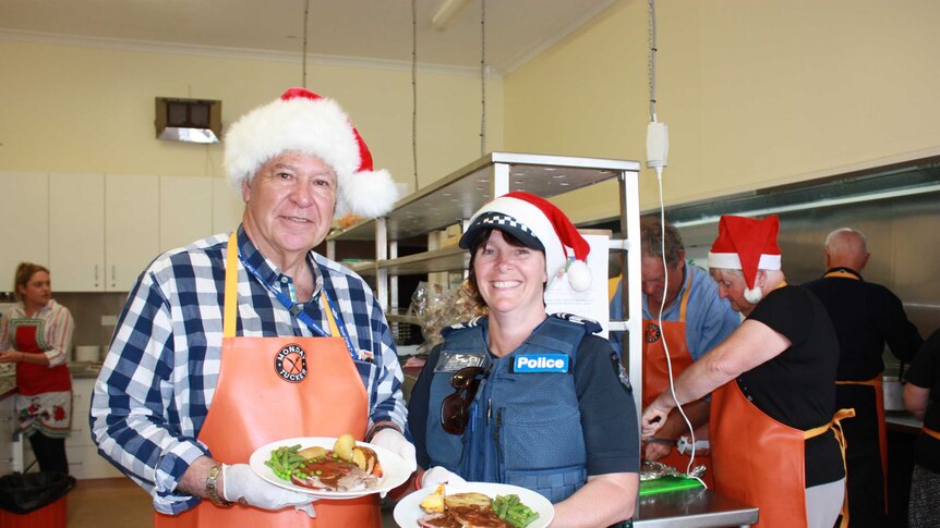 Michael Page and Rose Basford hold roast meal in commercial kitchen,