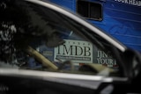 1MDB logo seen through a car window.