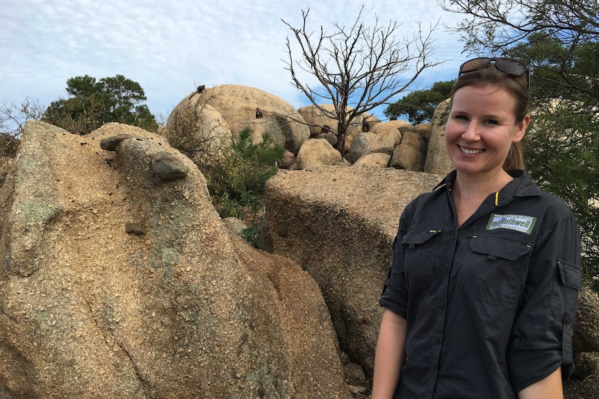 Annette Rypalski stands in front of four rock wallabies in the Grampians.