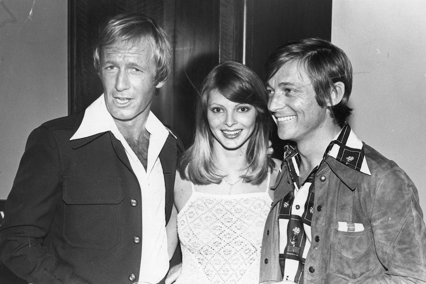 A black and white photo of Paul Hogan, Delvene Delaney and John Cornelll