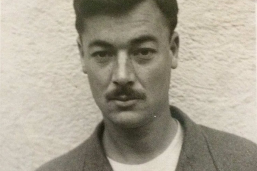 Black-and-white portrait of World War II veteran Bill Rudd, who has combed over hair and a moustache.