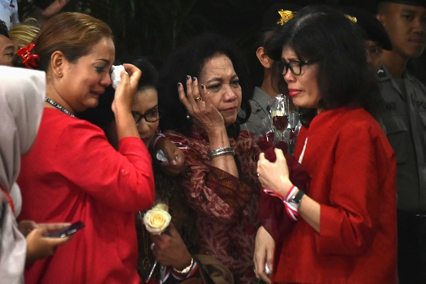 Three women cry after Jakarta's Christian governor Basuki Tjahaja Purnama is found guilty.