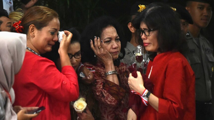 Three women cry after Jakarta's Christian governor Basuki Tjahaja Purnama is found guilty.