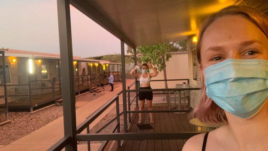 Megan Evans is wearing a mask and taking a selfie from the quarantine facility in Howard Springs.