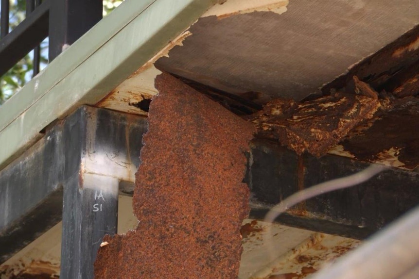 A photo of a rusted sheet peeling off a defective home.