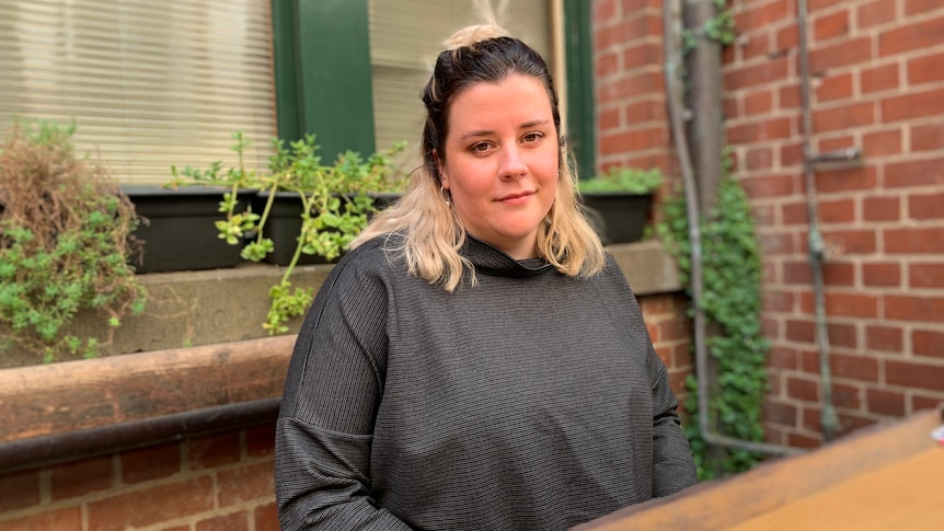 A woman sits at a table outdoors