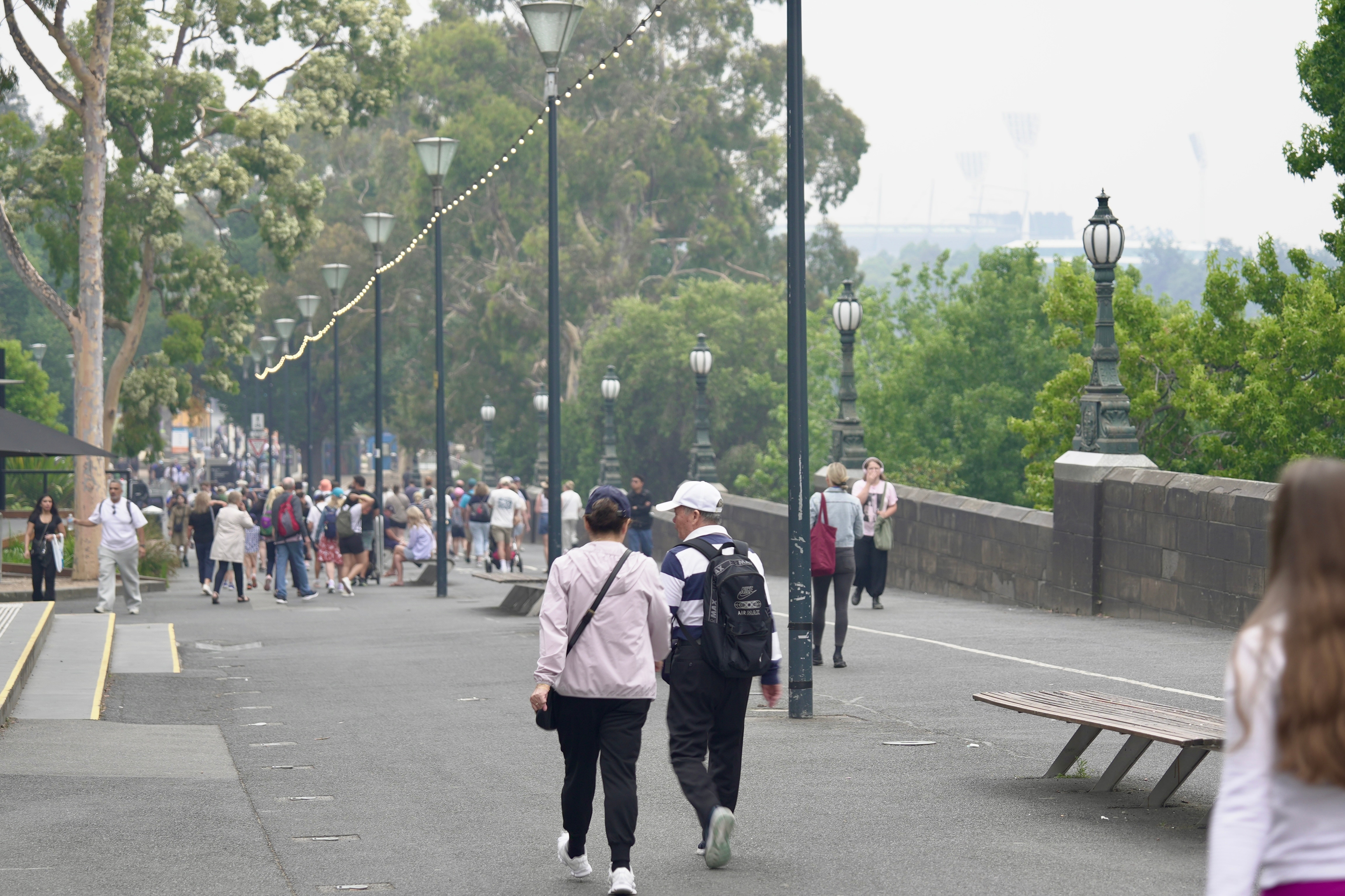 Grupos de personas caminando por los parques de Melbourne. 