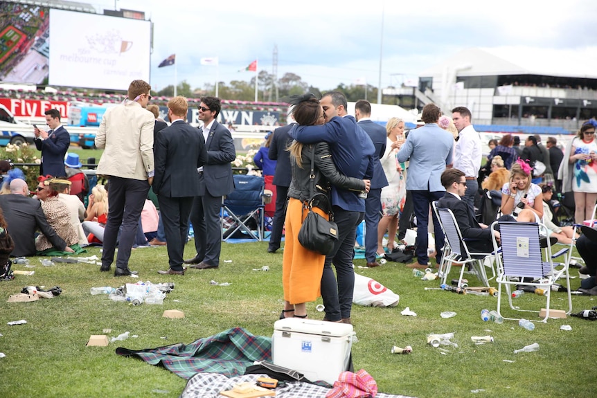 Couple kiss amongst the party-goers and trash