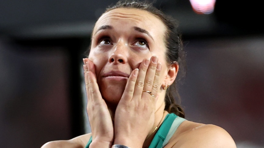 An Australian javelin thrower with her hands on her face as she reacts to winning a medal at the World Athletics Championships.