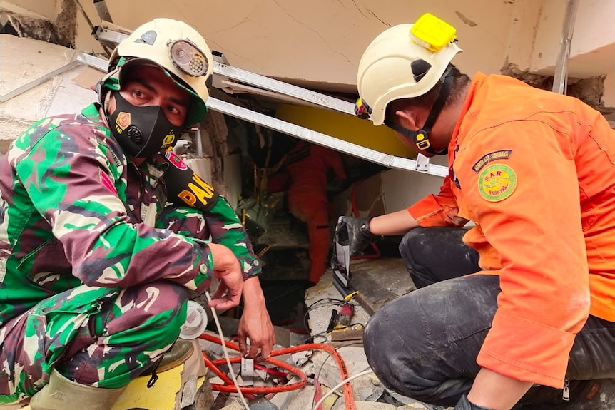 Members of a search and rescue agency team work after an earthquake, in Mamuju.