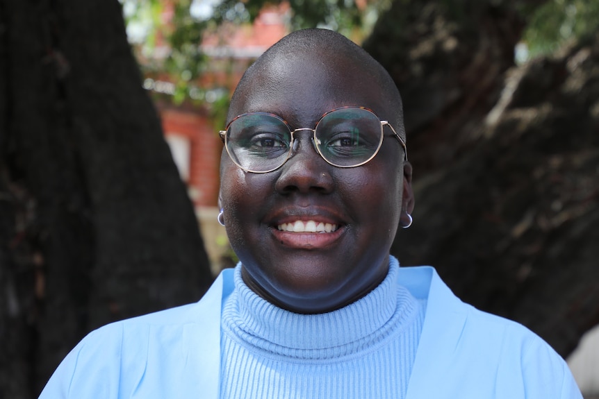 A woman with glasses and a blue jumper