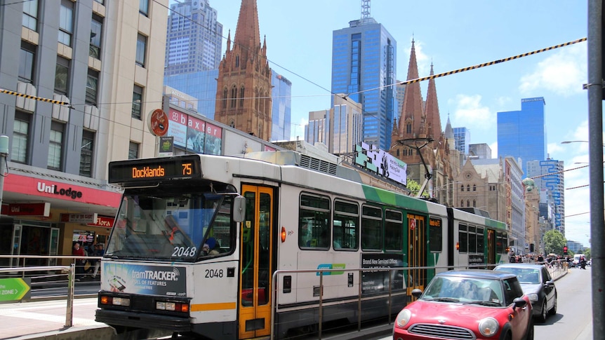 A number 75 tram travels along Flinders Street in Melbourne's CBD