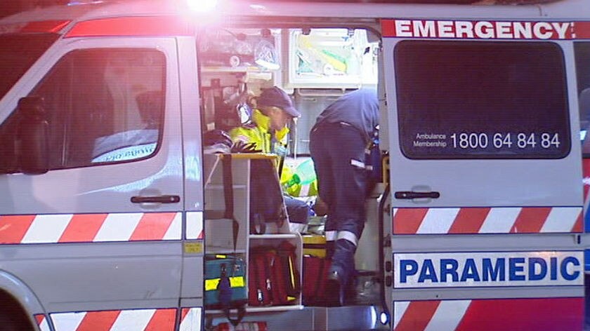 paramedics work on a patient in the back of an ambulance.