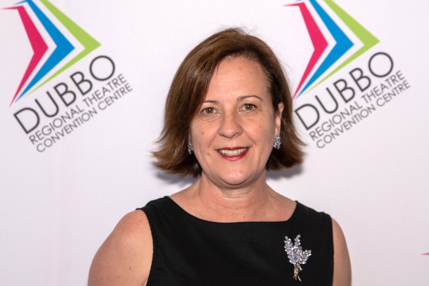 Linda Christof smiling in front of a backdrop labelled with Dubbo Regional Theatre and Convention Centre.