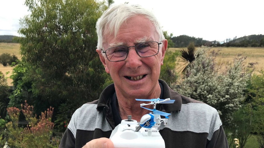 Scientific toy collector Peter Manchester with a tiny toy helicopter on his hand