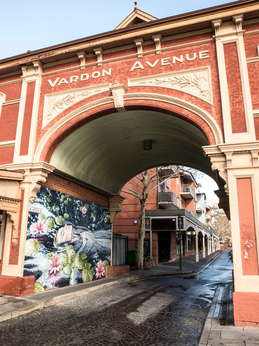 A heritage archway with apartment buildings behind it.