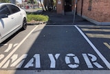 An empty car space with the word mayor painted on it