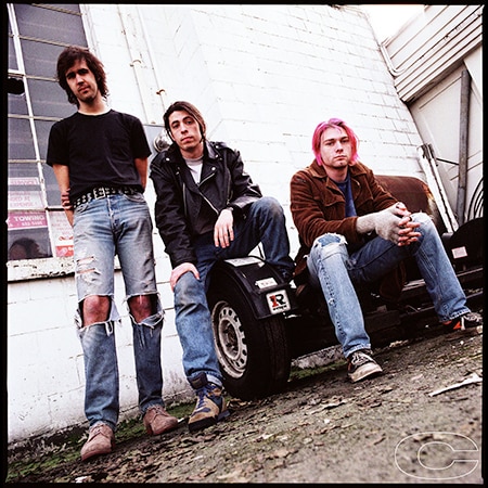 Kirst Novocelic, Dave Grohl and Kurt Cobain sit in an alleyway