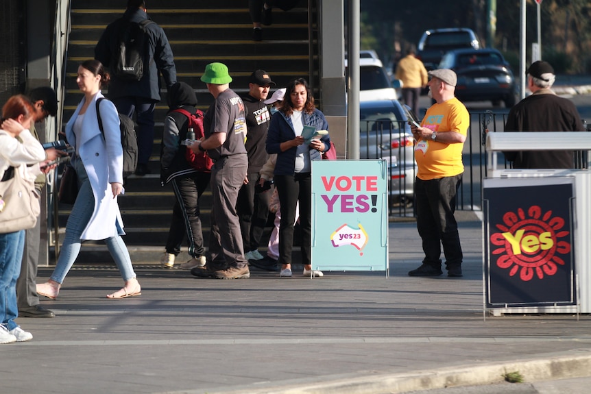 A man stands next to a Yes sign.