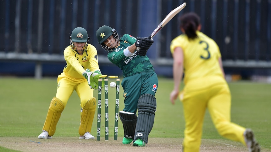 Pakistan batter Iram Javed completes her swing as a cricket ball hits her stumps. Australia wicketkeeper Alyssa Healy is behind.