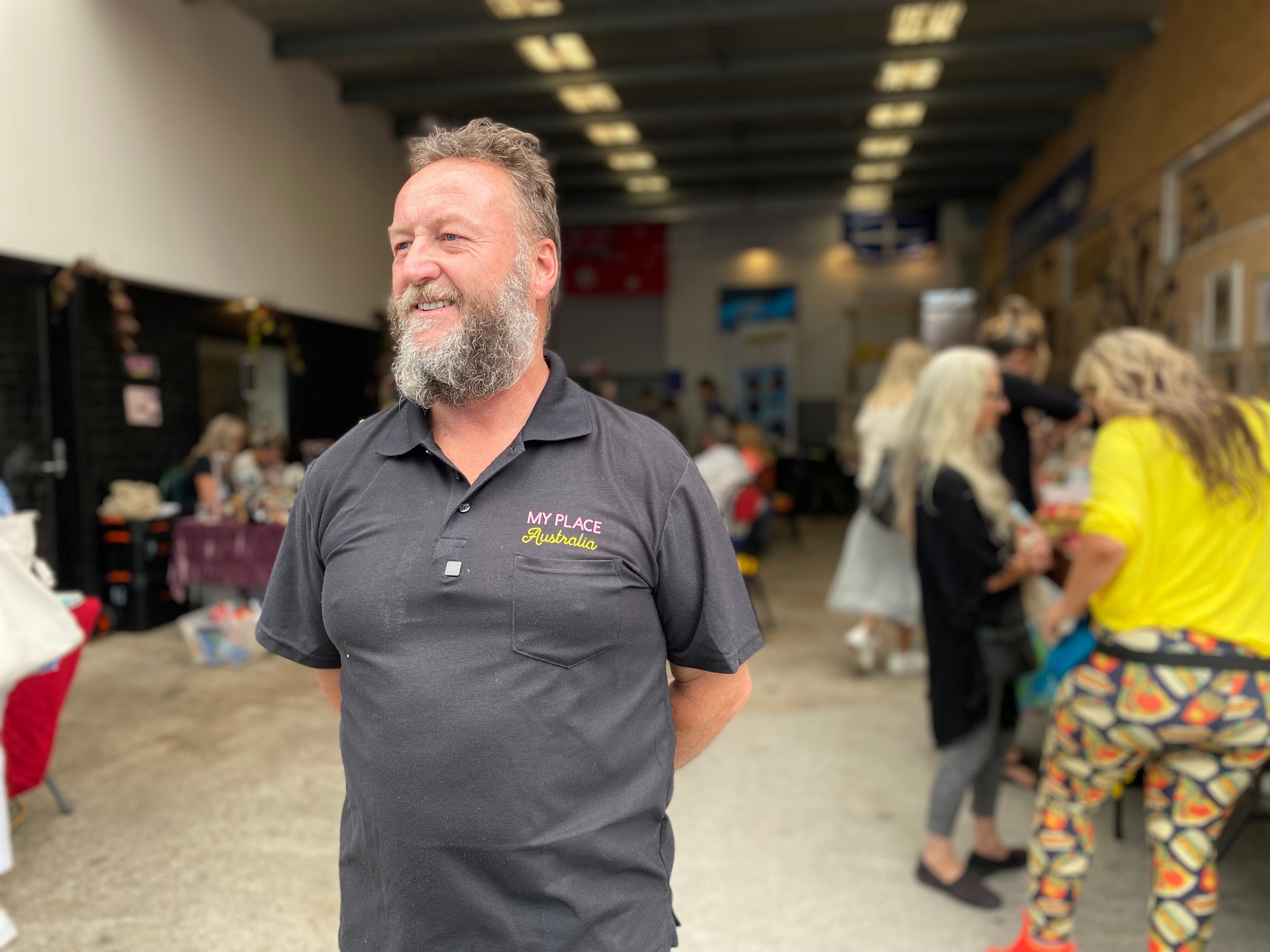 A man with a beard smiles.