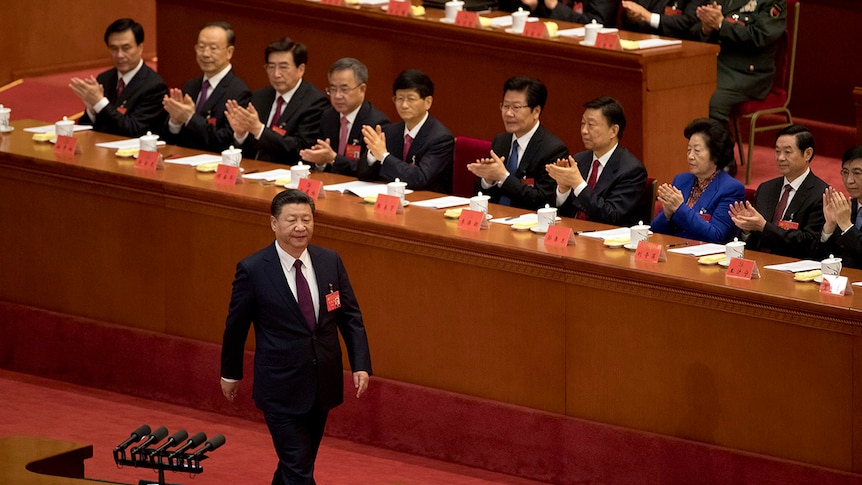 Chinese President Xi Jinping is applauded as he walks to the podium to deliver a speech in front of party members.