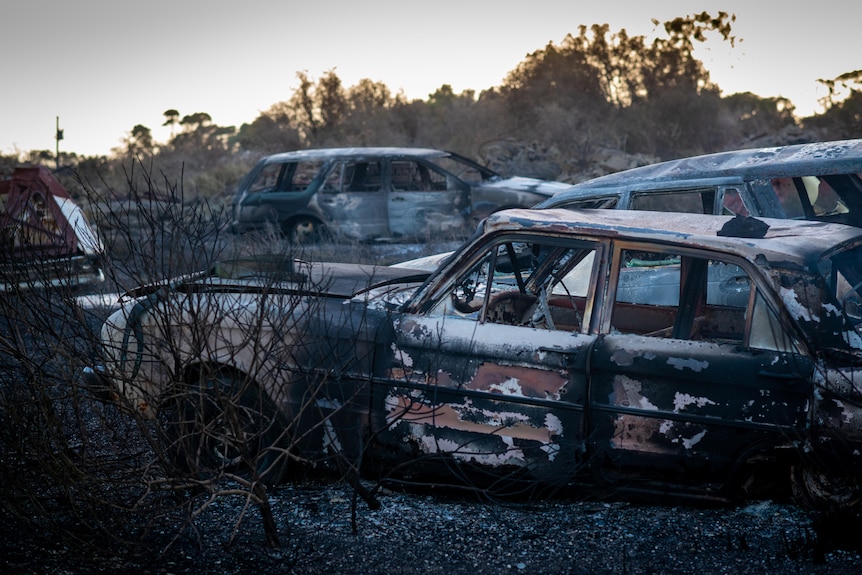 Three burnt out cars parked near each other