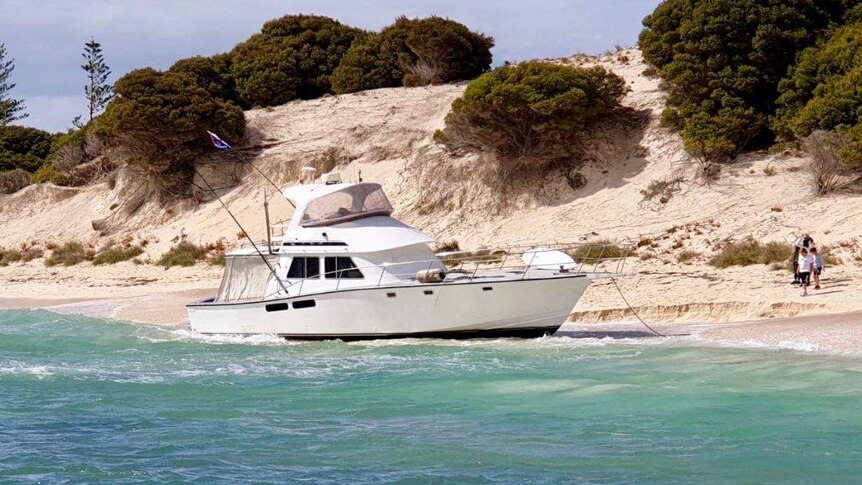 A wide shot of a 50-foot cruiser washed up on the beach on Rottnest Island.