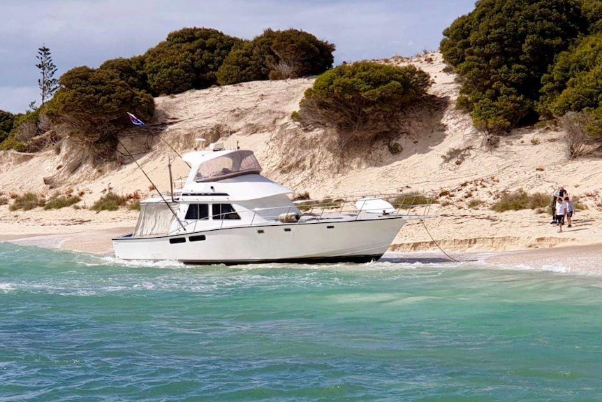 A wide shot of a 50-foot cruiser washed up on the beach on Rottnest Island.