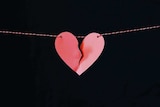 A paper heart hanging on a string is ripped in half to depict how to survive an affair.