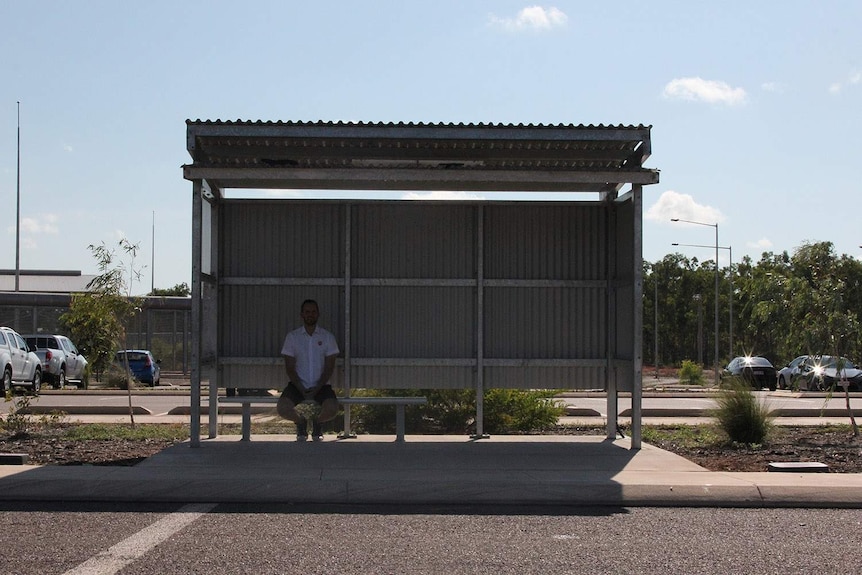 A bus stop with a sole man waiting