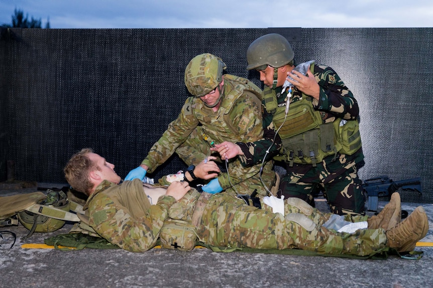 An Australian soldier and a Filipino soldier provide medical care during an urban combat skills demonstration.