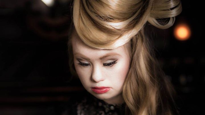Madeline Stuart looks down, her hair swept up to the right.